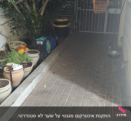 שביל מרוצף עם עציצים ושער מתכת